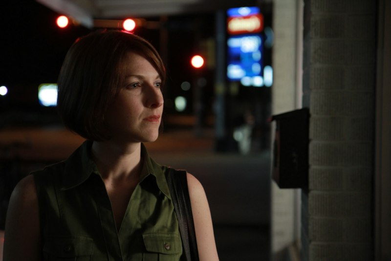 Woman looks inside convenience store window