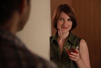 Woman holds cocktail in motel room